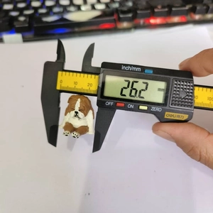 Detail view of a resin bulldog figurine measured with a digital caliper showing 26.2 mm
