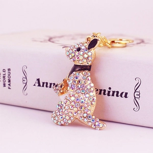 Golden kangaroo keychain with rainbow rhinestones and black enamel accents on white book