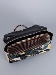 Detailed top view of embroidered straw shoulder bag with striped lining and gold hardware