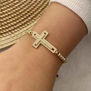 Close-up of 18K gold plated cross bracelet with pavé cubic zirconia on a wrist
