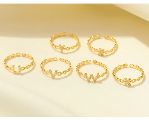 Macro detail of S925 sterling silver gold rings with zircon letters and hallmark