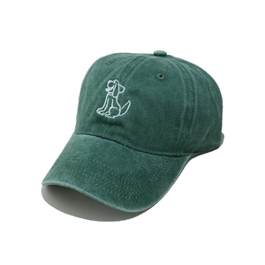 Macro detail of dark green washed cotton baseball cap featuring white puppy embroidery