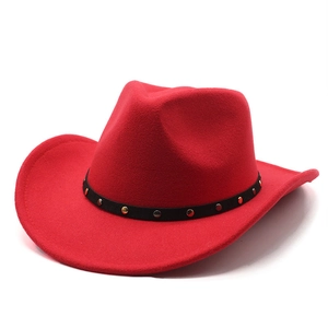 Detail of red cowboy hat with black leather band featuring gold and silver metal studs