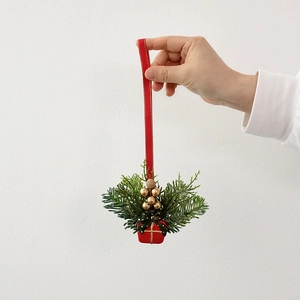 Christmas tree ornament with red gift box, green pine needles and gold berries