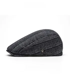 Side view of gray knit ivy cap showing fine striped texture and decorative metal plaque