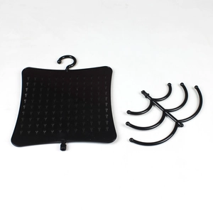 Detail view of black plastic jewelry display stand with perforated holes and hanging hooks