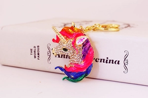 Close-up of a colorful enamel unicorn keychain with gold metal plating and crystal rhinestones
