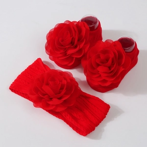 Détail d'un ensemble bandeau et chaussettes rouges pour bébé avec fleurs en mousseline
