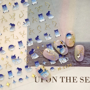 Cartoon planet rabbit nail art stickers with 3D gold foil details on blue gradient base