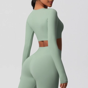 Détail d'un ensemble de yoga vert sauge avec haut court à manches longues et legging