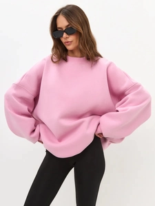 Street style shot of oversized pink crewneck sweatshirt with drop shoulder and long sleeves