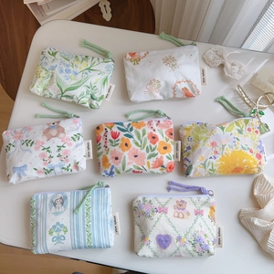 Detailed shot of various floral cotton mini pouches with zippers and woven pullers