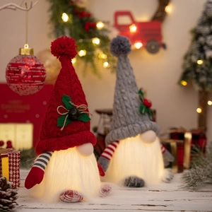 Close-up of lighted Christmas gnomes with knitted hats and glowing plush beards