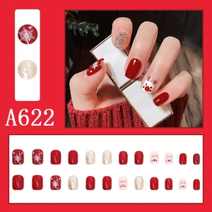 Detail view of 24pcs Christmas press-on nails with red reindeer and snowflake designs