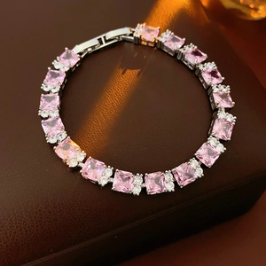 Primer plano de pulsera de circonita rosa con engaste plateado sobre caja de cuero