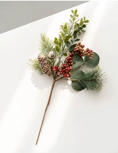 Christmas floral pick with pine cones, red glitter berries, and golden bells on white background