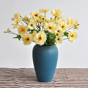 Artificial cream buttercup flowers with 3 heads in a blue matte ceramic vase for home decor