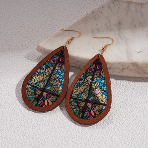 Macro detail of bohemian teardrop earrings with floral print inlay and wooden frame