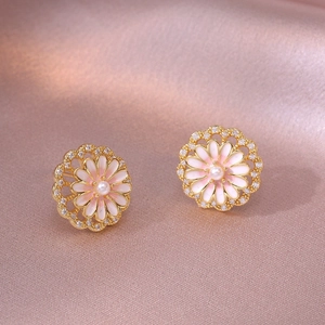 Macro view of floral stud earrings with pink enamel, white pearl, and zircon inlay