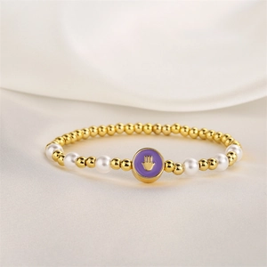 Détail macro du bracelet Hamsa perlé avec perles dorées et perles blanches sur soie
