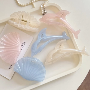 Pastel jelly shell and dolphin hair claws set on white tray with pearls for summer styling
