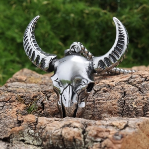 Detail shot of vintage silver satanic ram skull pendant on a rustic tree bark background