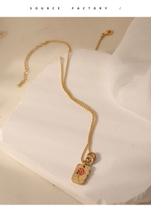 Detail of vintage flower pendant on hammered gold rectangle plate with red rose