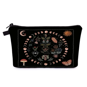 Detailed view of black fabric cosmetic bag featuring mystical moon and botanical illustrations