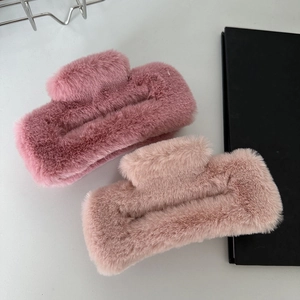 Detail view of large faux fur hair claws in pink showing soft plush texture and spring clip