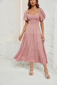 Détails du bustier froncé et des manches bouffantes sur une robe mi-longue rose