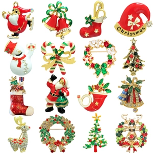 Grid display of Christmas brooches featuring Santa, trees, reindeer and bells in red and gold