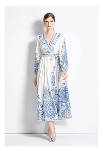Close-up of white maxi dress featuring blue ethnic prints and V-neck wrap design
