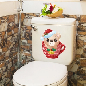 Close-up of a Christmas cartoon bear sticker on a white ceramic toilet tank surface