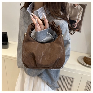 Detailansicht der braunen Handtasche mit Plissee-Struktur für einen eleganten Vintage-Stil
