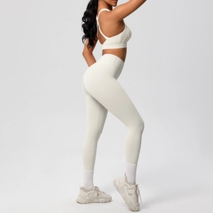Vista lateral de conjunto de sujetador deportivo cruzado y leggings de yoga blancos