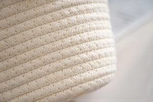 Detailed close-up of woven cotton rope texture on a stylish cream tote bag