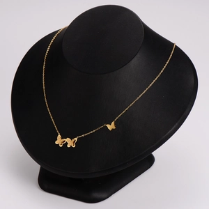 Gold butterfly pendant necklace with frosted details displayed on a black bust mannequin