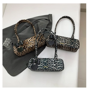 Detailed view of leopard print shoulder bags featuring decorative bows and heart charms