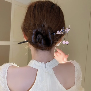 Detail of purple flower hair pin with pearls and tassels in a traditional updo