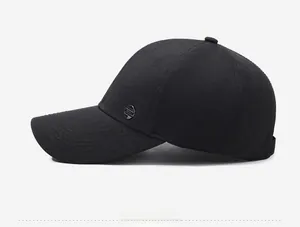 Dettaglio cappellino da baseball nero con stemma metallico sportivo sul lato laterale
