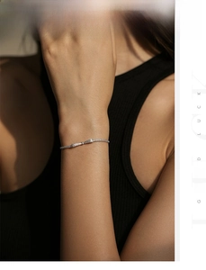 Close-up of sparkling 925 sterling silver bow bracelet with pavé diamonds on model's wrist
