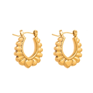 Détail macro de boucles d'oreilles dorées en U avec texture ondulée et finition polie