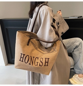 Brown suede tote bag styled with a khaki trench coat for a minimalist aesthetic