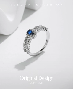 Macro shot of s925 silver ring featuring blue oval gemstone and pavé-set diamonds