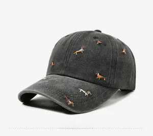Detail view of washed canvas texture and colorful dachshund embroidery on dark grey cap