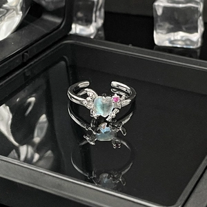 Detailed view of silver bow ring featuring moonstone heart and pink gemstones decoration