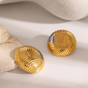 Gros plan sur des boucles d'oreilles bicolores or et argent avec rainures radiales