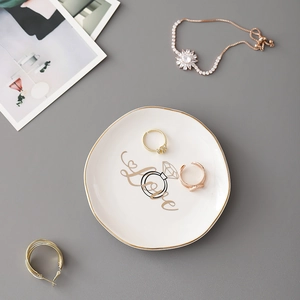 Irregular white ceramic jewelry tray with gold edge and love print in flat lay view