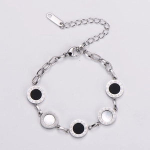 Detail of stainless steel bracelet featuring Roman numeral discs with shell inlay