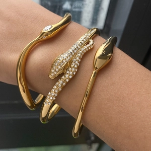 Three-piece gold-plated stainless steel bracelet set featuring a rhinestone-paved snake design